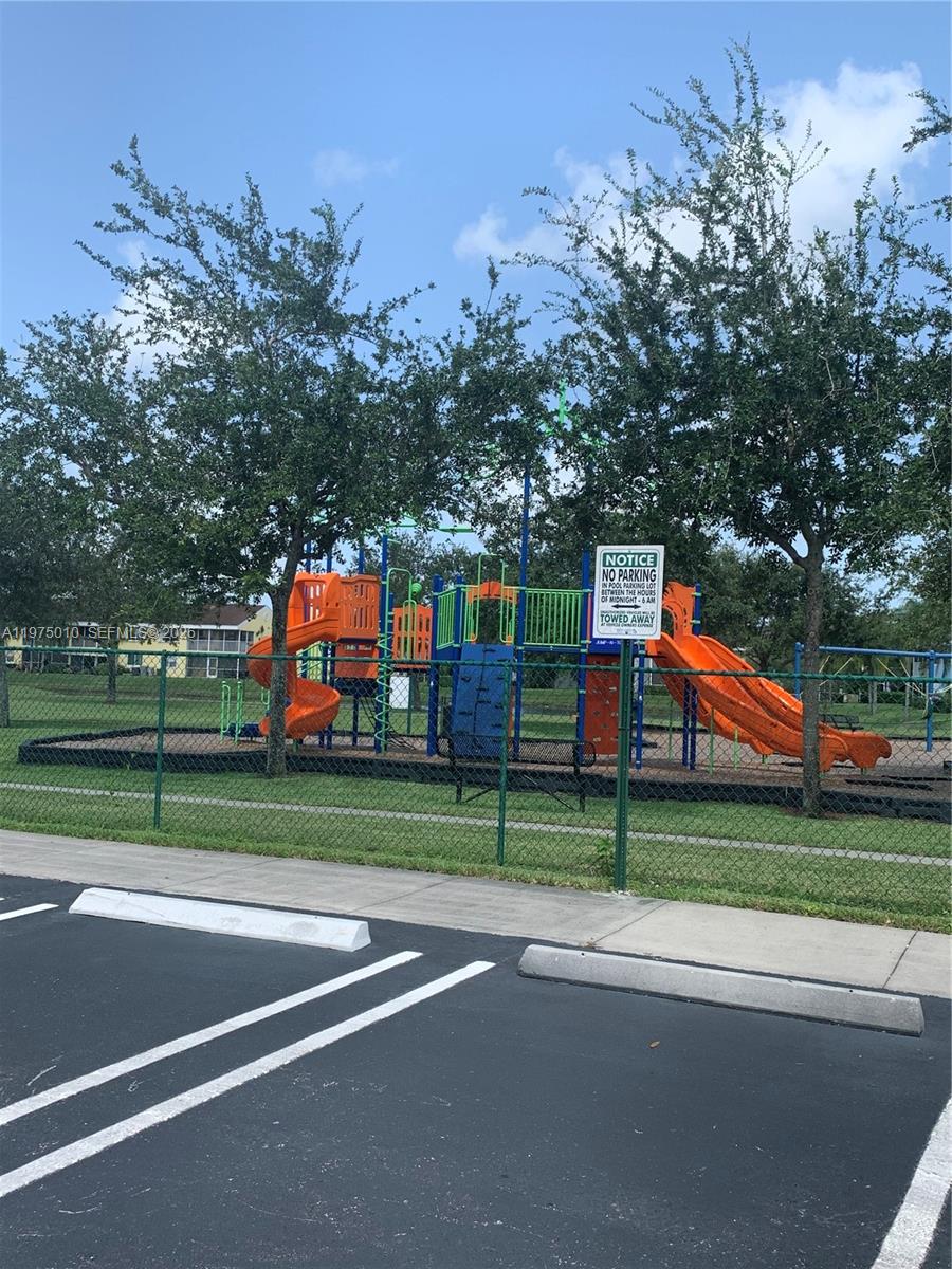 2211 Southeast 23rd Road, Unit 2211 Homestead, FL 33035 - Photo 32 of 39 a view of road with a big yard and large trees