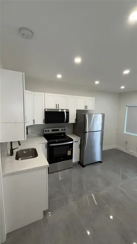 a kitchen with stainless steel appliances a stove a sink and a refrigerator