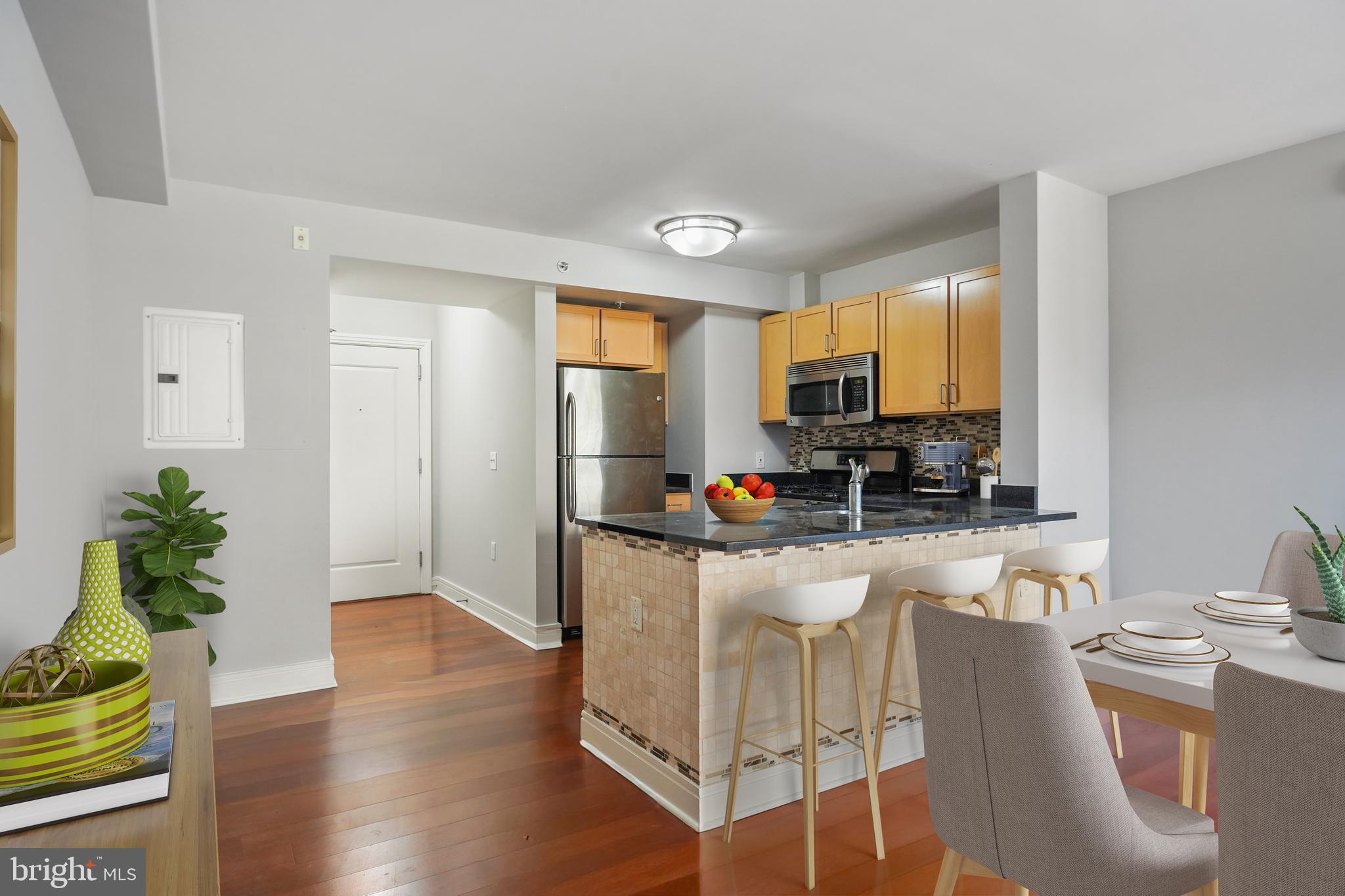 800 4th Street Southwest, Unit N111 Washington, DC 20024 - Photo 11 of 27 a kitchen with stainless steel appliances granite countertop a refrigerator a stove top oven a sink dishwasher and white cabinets with wooden floor