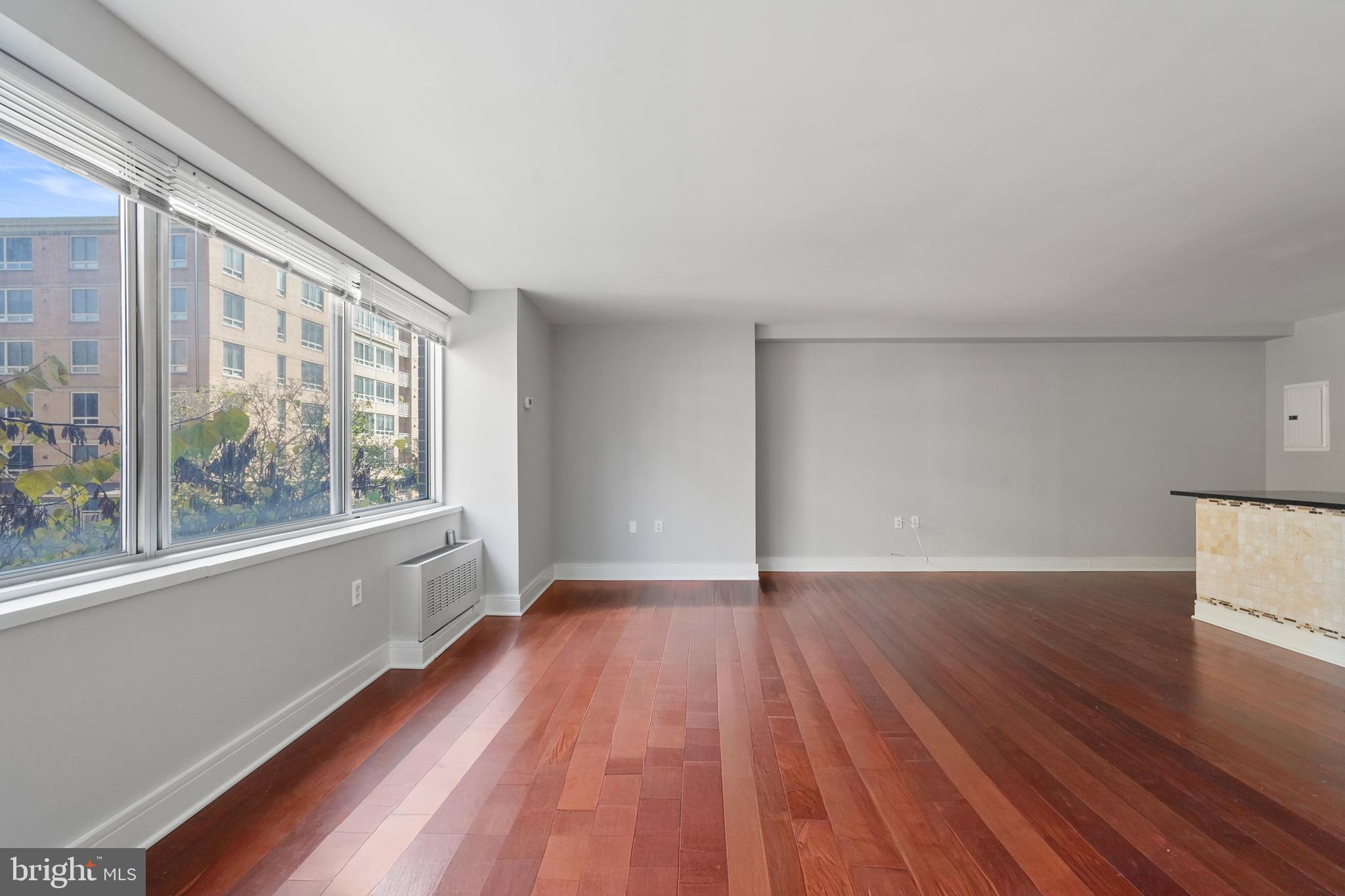 800 4th Street Southwest, Unit N111 Washington, DC 20024 - Photo 12 of 27 a view of an empty room with wooden floor and a window