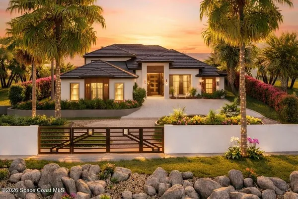 a front view of a house with a yard and potted plants