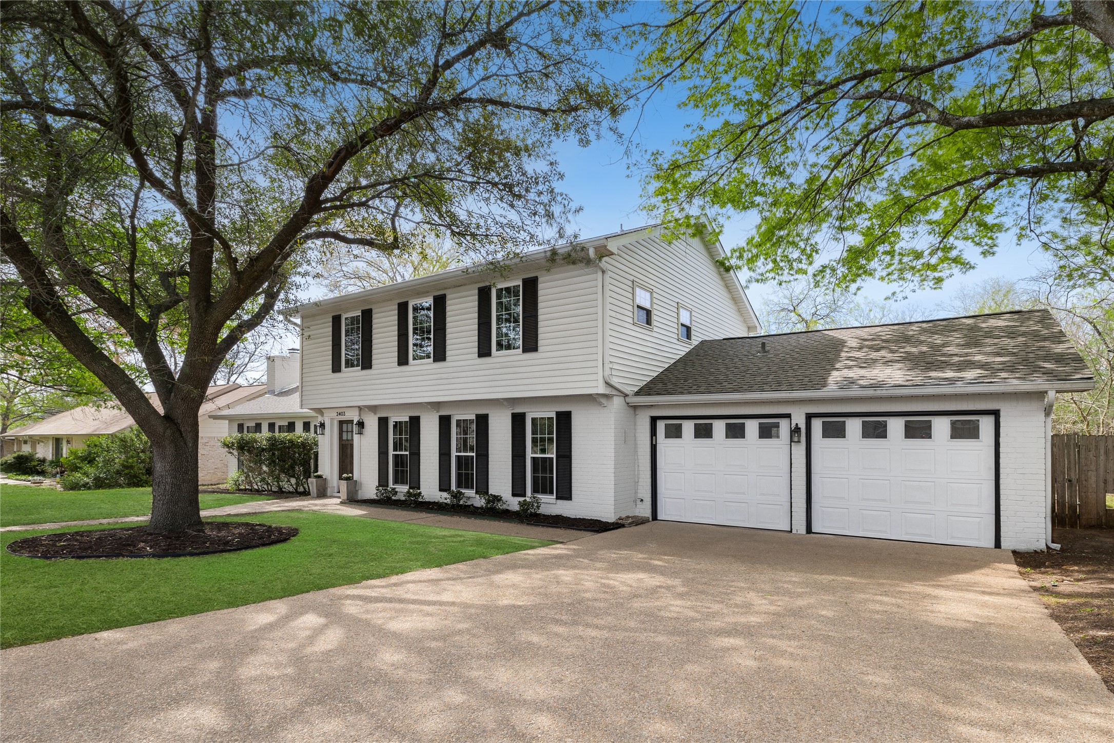2403 Comburg Castle Way Austin, TX 78748 - Photo 2 of 40 Colonial-style house featuring brick siding, a garage, concrete driveway, and roof with shingles