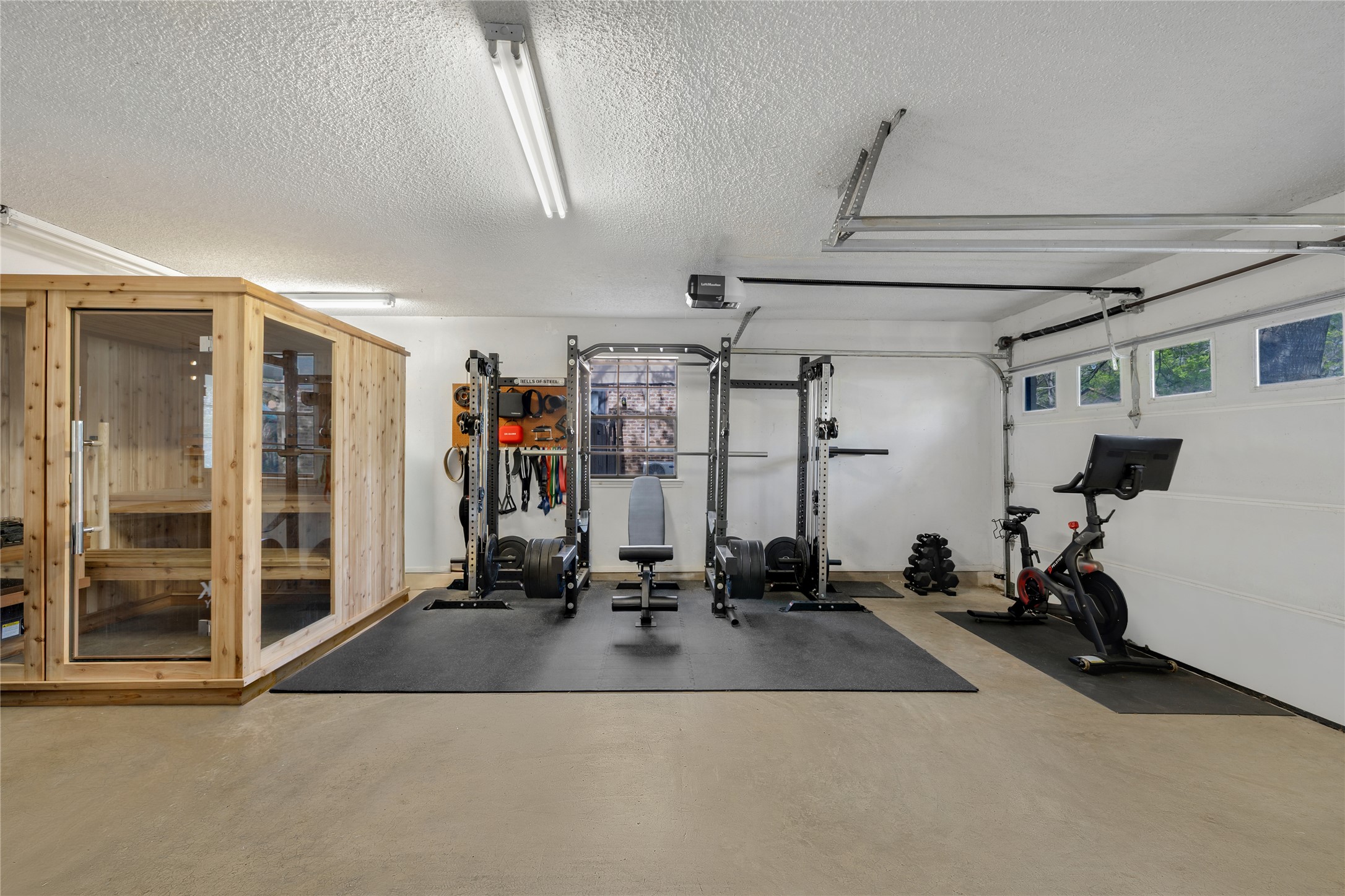2403 Comburg Castle Way Austin, TX 78748 - Photo 21 of 40 Exercise room with a sauna / steam room, concrete flooring, a textured ceiling, and a garage