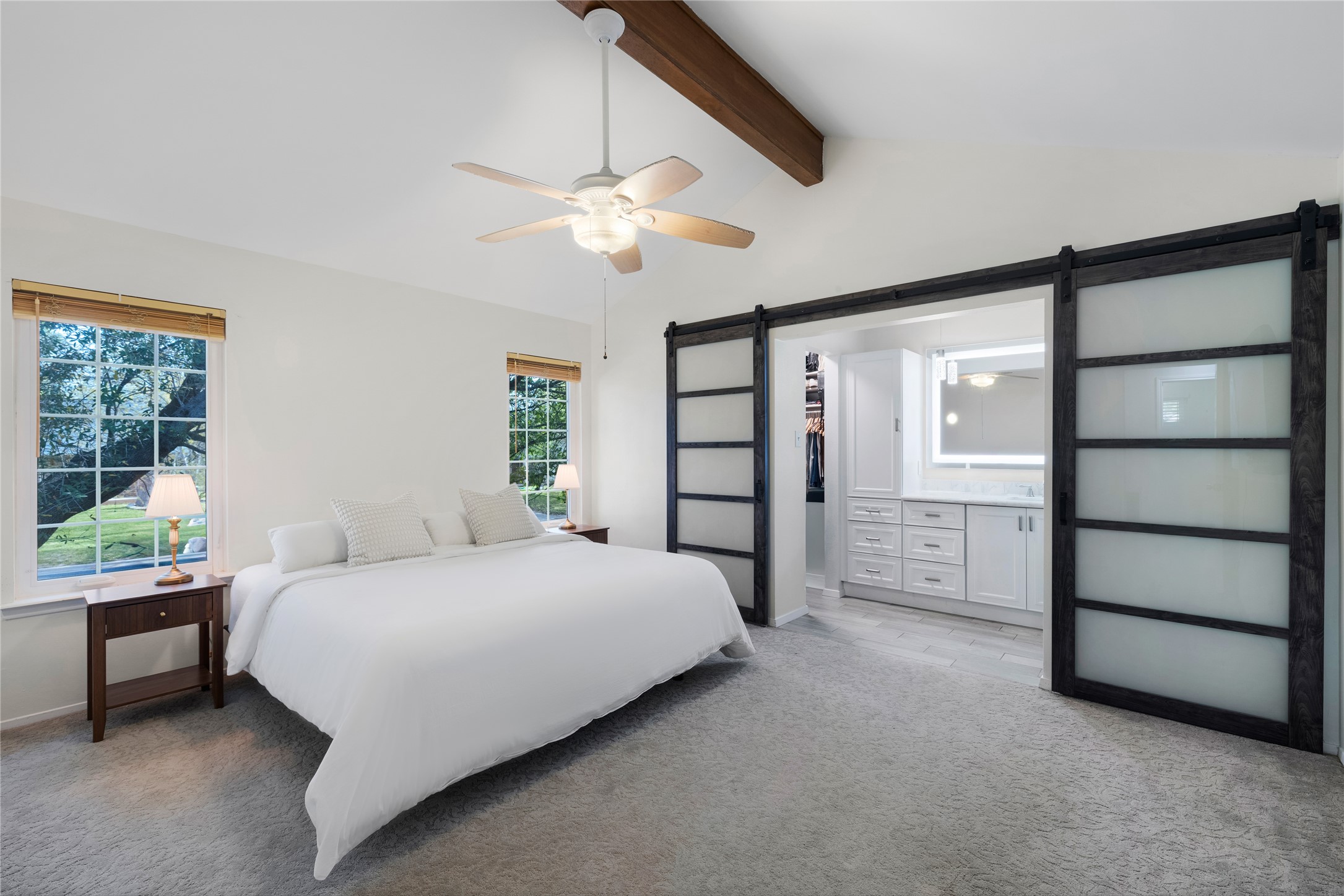 2403 Comburg Castle Way Austin, TX 78748 - Photo 22 of 40 Bedroom with a barn door, carpet flooring, a spacious closet, beam ceiling, and connected bathroom
