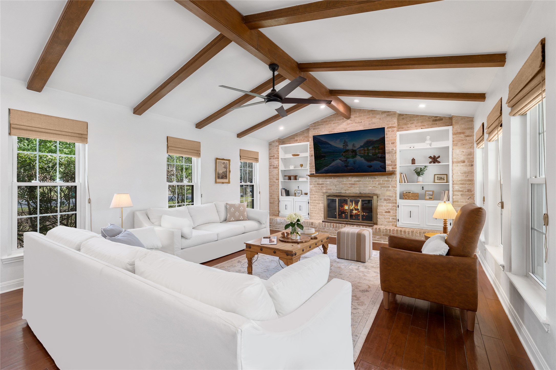2403 Comburg Castle Way Austin, TX 78748 - Photo 9 of 40 Living area with plenty of natural light, dark wood finished floors, a fireplace, beamed ceiling, and built in shelves