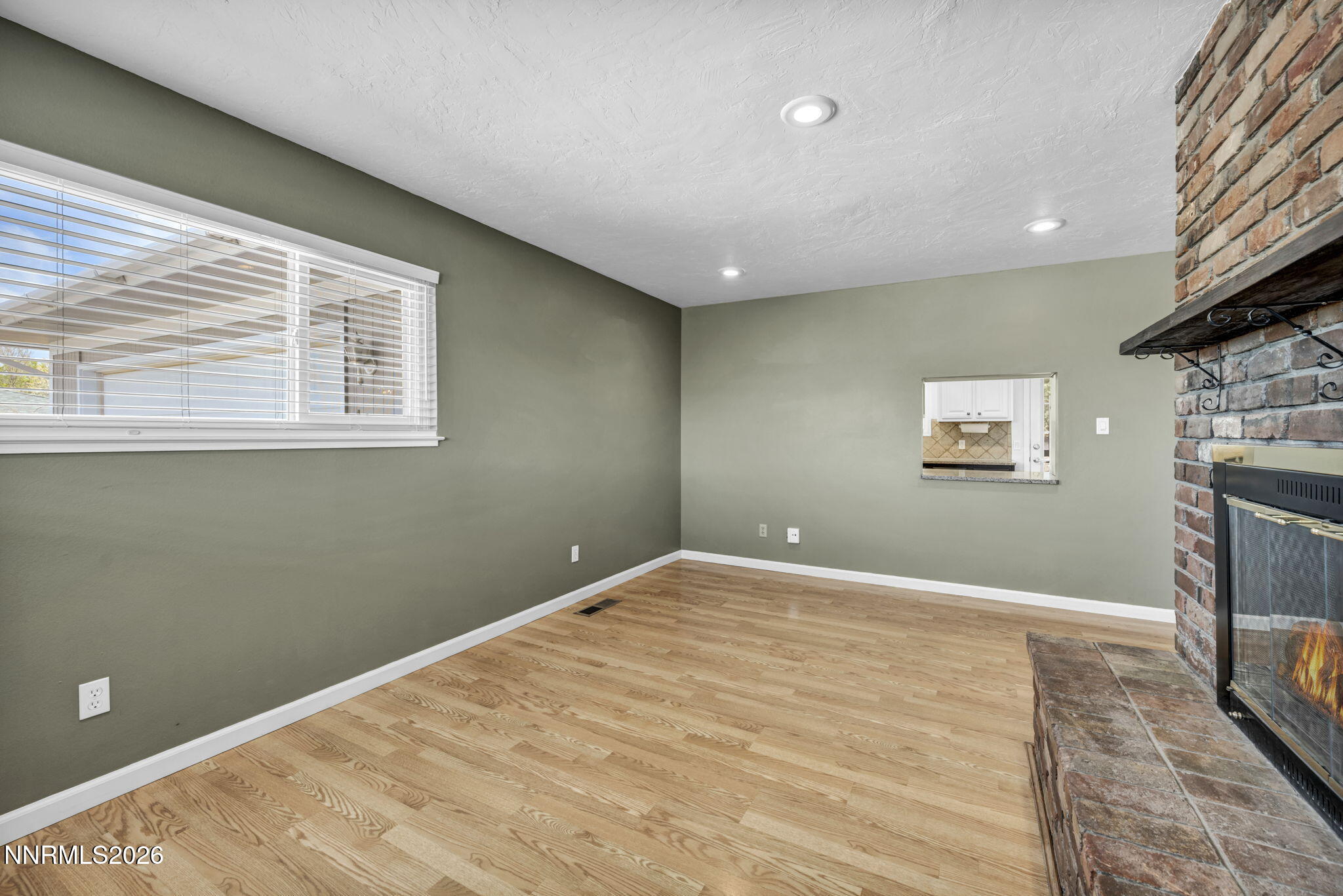 14190 Rim Rock Drive Reno, NV 89521 - Photo 12 of 68 a view of empty room with a fireplace and wooden floor