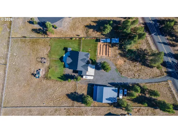 an aerial view of a house with a yard and outdoor seating