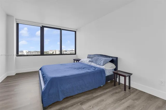 a view of a bedroom with wooden floor and a window