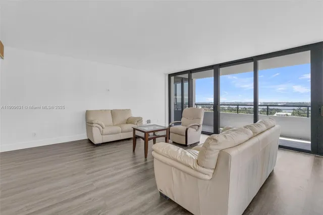 a view of a dining room with furniture large windows and wooden floor