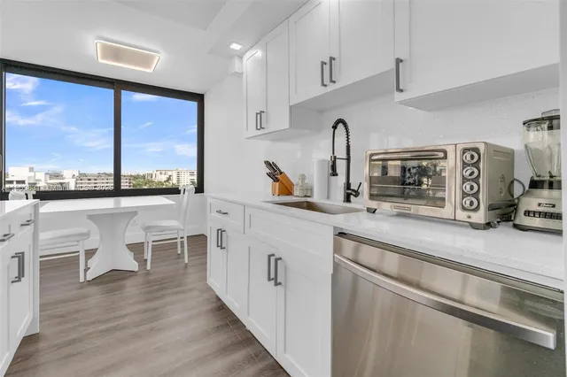 a kitchen with a sink cabinets and wooden floor