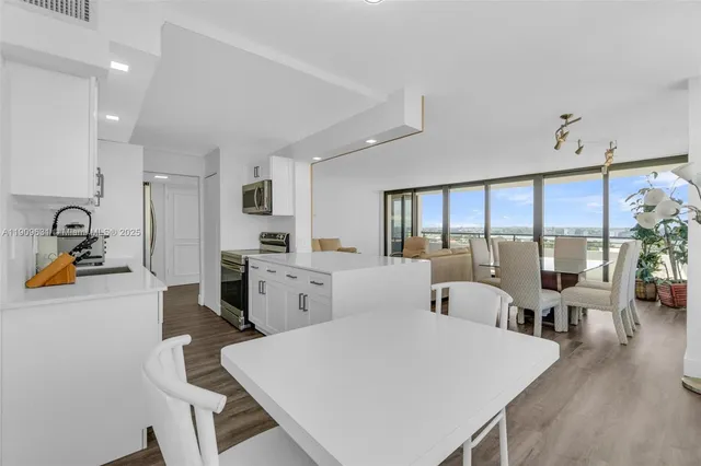 a large white kitchen with sink and refrigerator