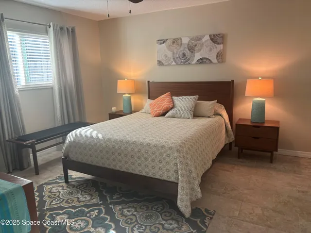 a bedroom with a bed and a lamp on dresser