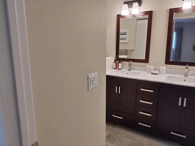 a bathroom with a double vanity sink and a mirror