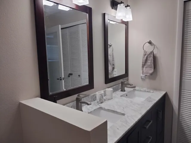 a bathroom with a granite countertop sink and a mirror