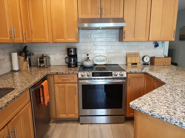 a kitchen with granite countertop a stove sink and cabinets