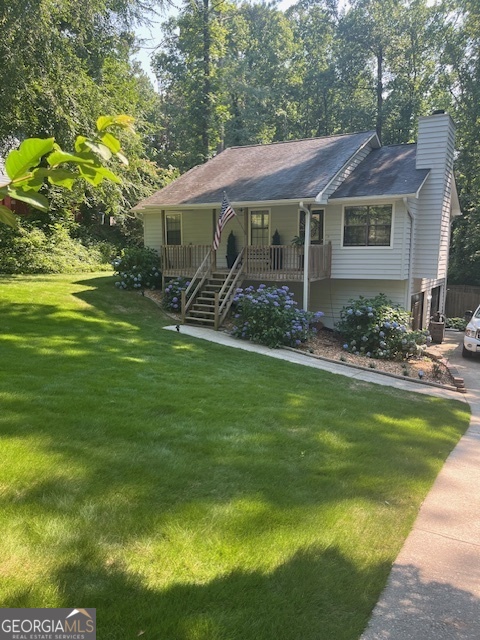 a view of a house with a yard potted plants and large tree
