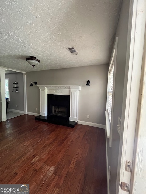 1221 Martin Nash Road Southwest Lilburn, GA 30047 - Photo 11 of 31 an empty room with wooden floor and fireplace