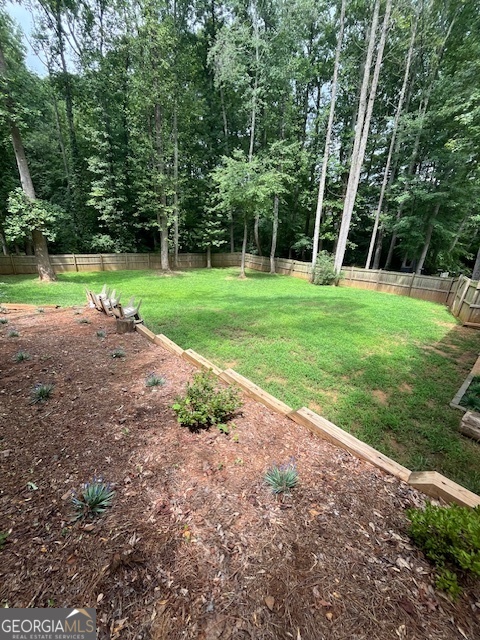1221 Martin Nash Road Southwest Lilburn, GA 30047 - Photo 5 of 31 a view of a yard with plants and large trees