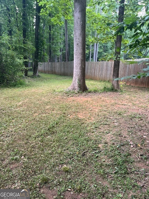 1221 Martin Nash Road Southwest Lilburn, GA 30047 - Photo 7 of 31 a backyard of a house with lots of plants and large tree