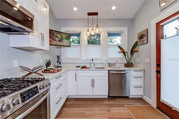 a kitchen with stainless steel appliances a sink stove and cabinets