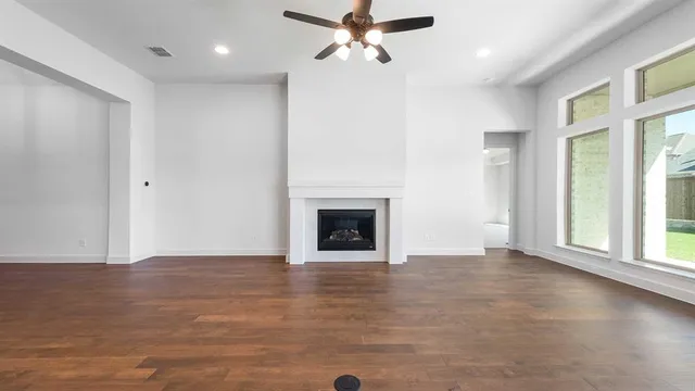 an empty room with windows and a fireplace
