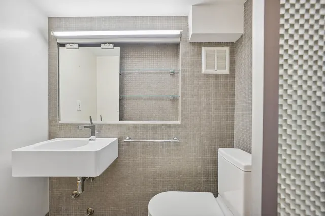 a bathroom with a toilet sink and mirror
