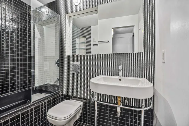 a bathroom with a toilet a sink and mirror