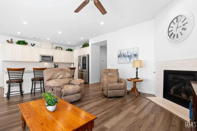 a large living room with stainless steel appliances kitchen island granite countertop a couch and a flat screen tv