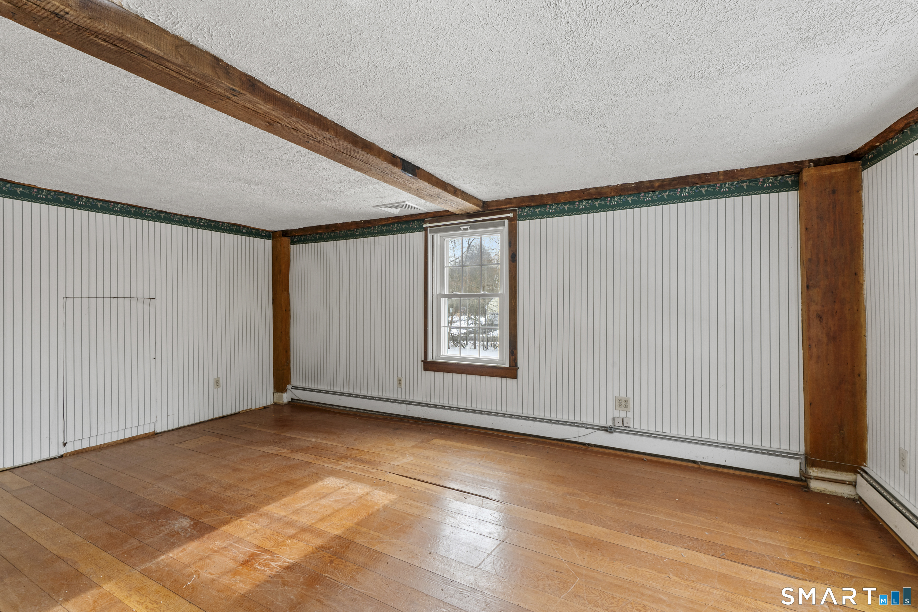 392 Boston Neck Road Suffield, CT 06078 - Photo 23 of 35 a view of an empty room with wooden floor and a window