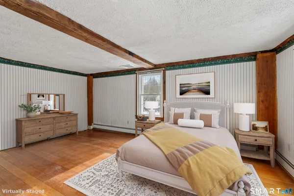 a spacious bedroom with a large bed and a wooden floor