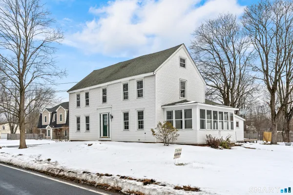 a view of a house with a yard covered in snow