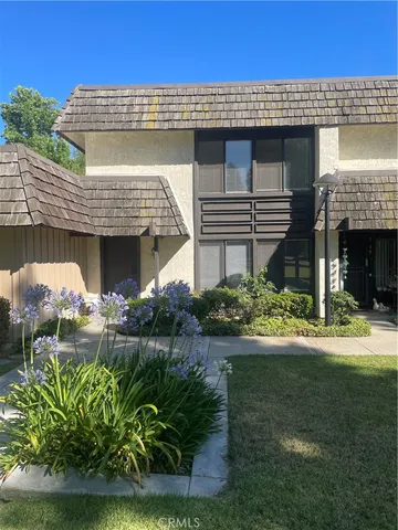 a front view of a house with a yard and potted plants