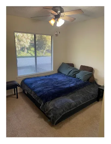 a bed sitting in a bedroom next to a window