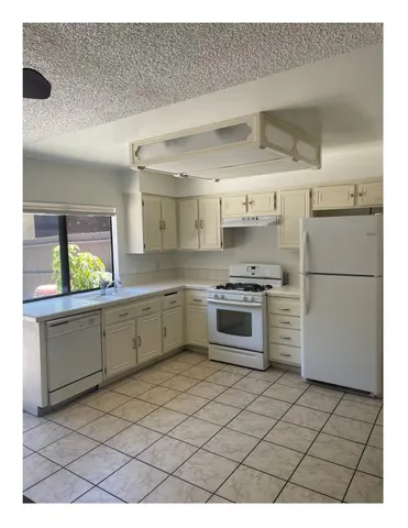 a kitchen with stainless steel appliances a refrigerator sink and cabinets