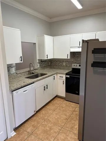 a kitchen with granite countertop a sink stove and refrigerator