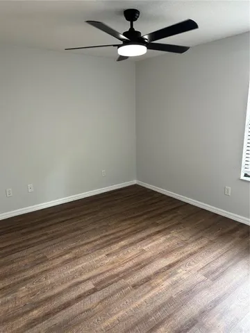 a view of a room with wooden floor cabinets and a ceiling fan