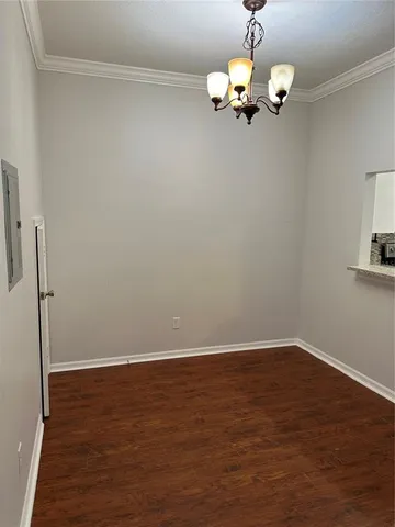 a view of a room with wooden floor and chandelier