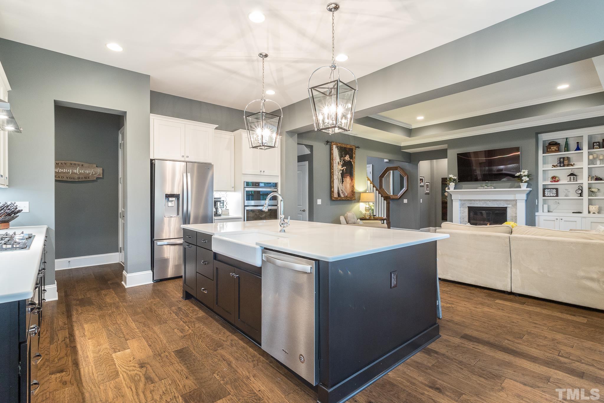 5281 Aleppo Lane Raleigh, NC 27613 - Photo 21 of 57 a large kitchen with stainless steel appliances kitchen island granite countertop a large counter top and wooden floors