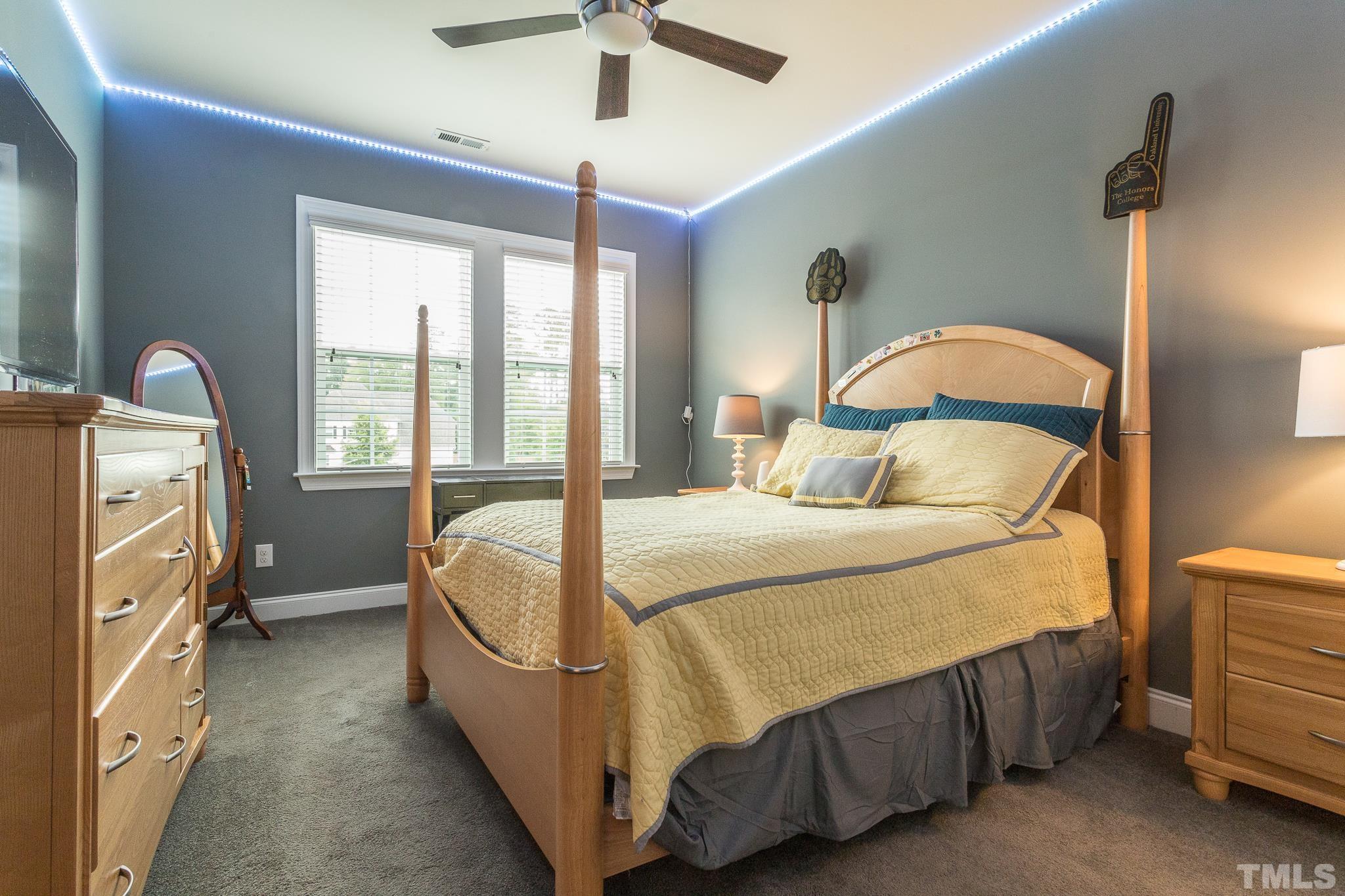 5281 Aleppo Lane Raleigh, NC 27613 - Photo 34 of 57 a bedroom with a bed and a chandelier