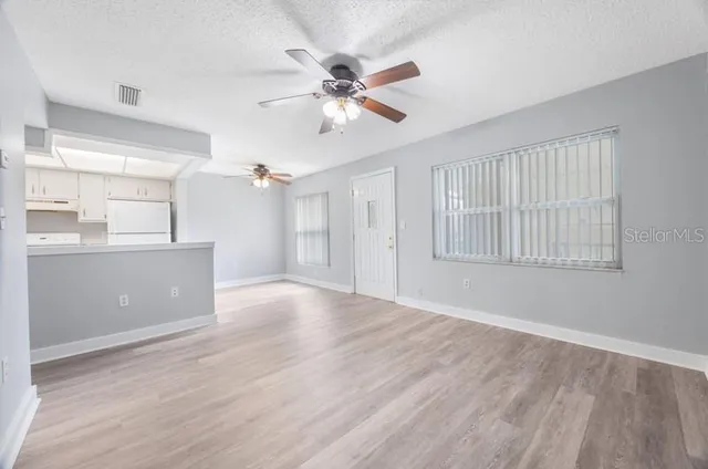 a view of a livingroom with a ceiling fan & wooden floor