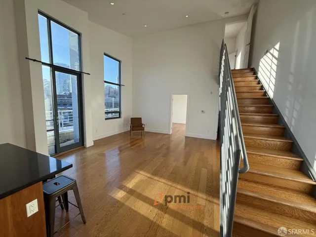 a view of a livingroom with wooden floor and stairs