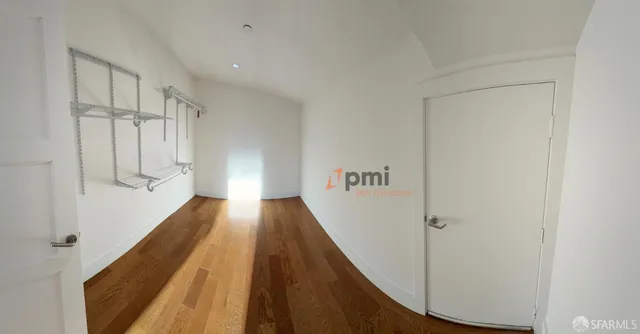 a view of a hallway with wooden floor and staircase