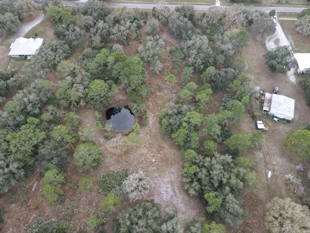 an aerial view of residential houses with outdoor space and trees