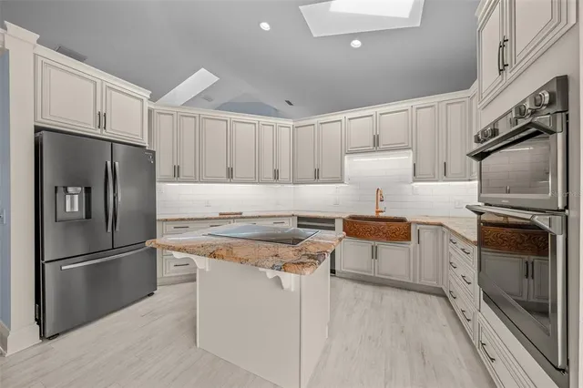 a kitchen with stainless steel appliances granite countertop a refrigerator stove and sink