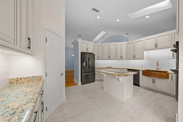 a kitchen with stainless steel appliances granite countertop a refrigerator and a sink