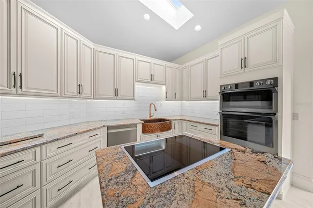 a kitchen with granite countertop a stove sink and cabinets