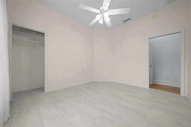 an empty room with a ceiling fan and a fan