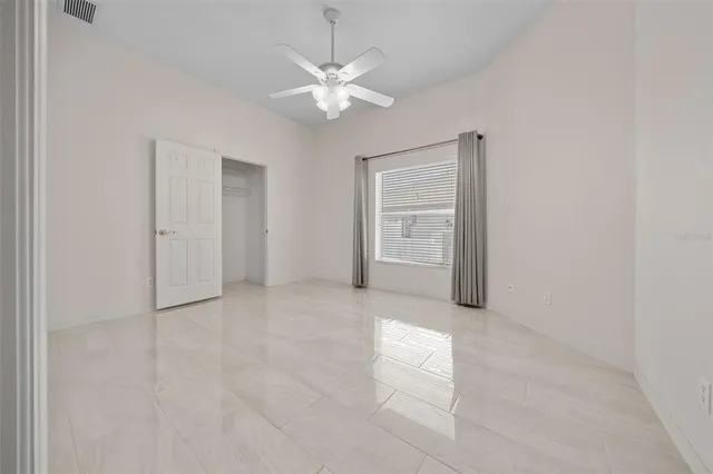 an empty room with fan and windows