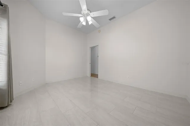 an empty room with a ceiling fan and a fan