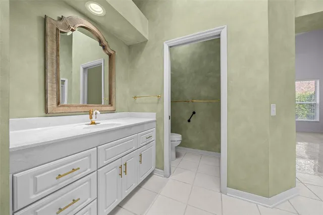 a spacious bathroom with a granite countertop sink mirror and toilet